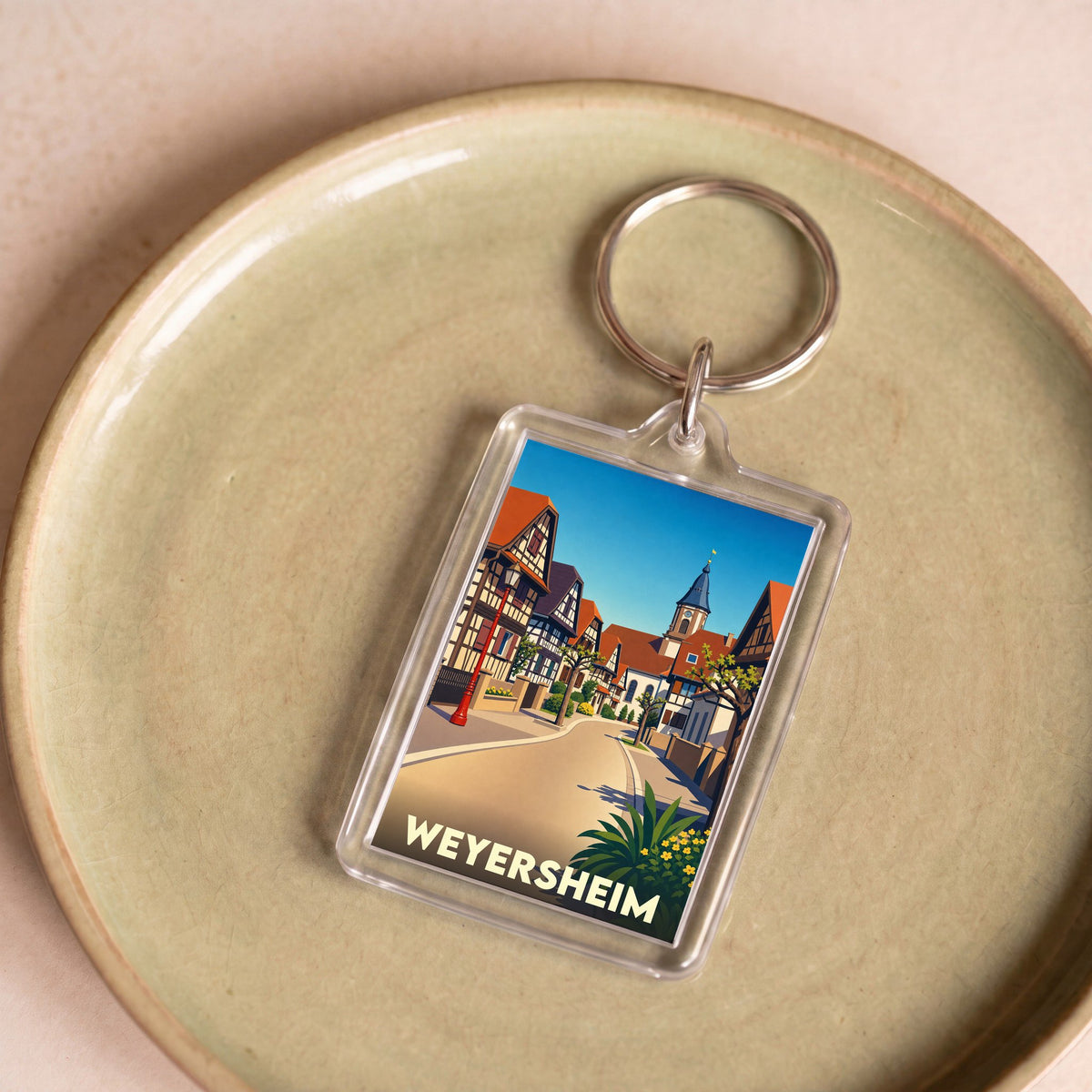 Porte-clés souvenir de la ville de Weyersheim avec une illustration stylisée de ses maisons à colombages.