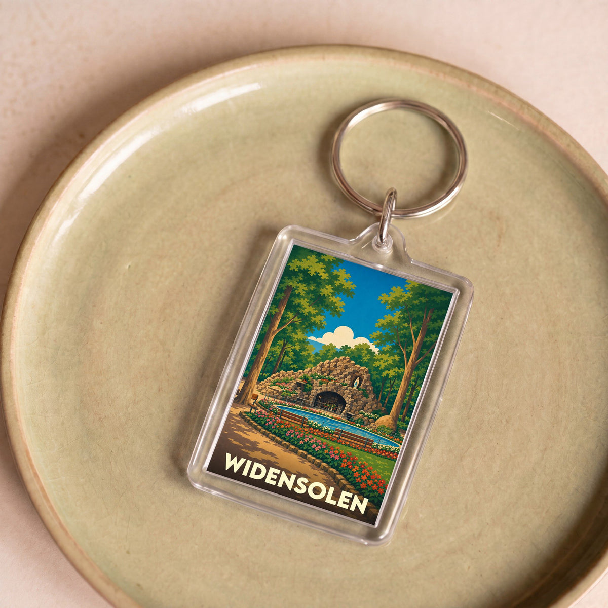 Porte-clés souvenir de la ville de Widensolen avec une illustration stylisée d'une grotte dans un parc arboré.