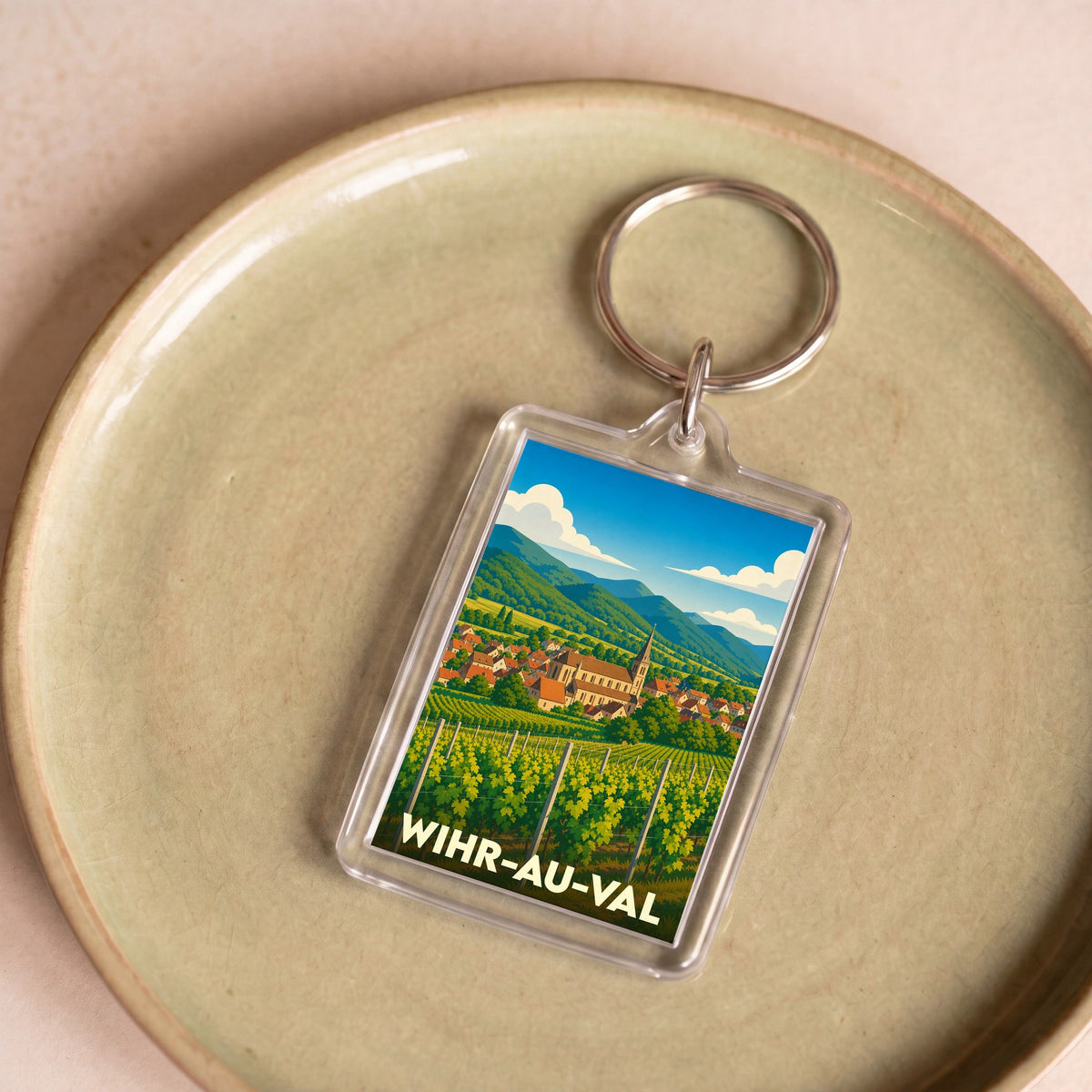 Porte-clés souvenir de la ville de Wihr-au-Val avec une illustration stylisée de son paysage et de ses vignobles.