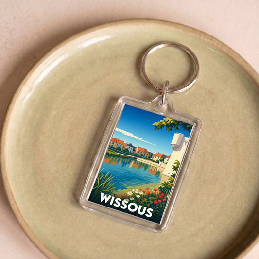 Porte-clés souvenir de la ville de Wissous avec une illustration stylisée et colorée d'un paysage urbain au bord de l'eau.