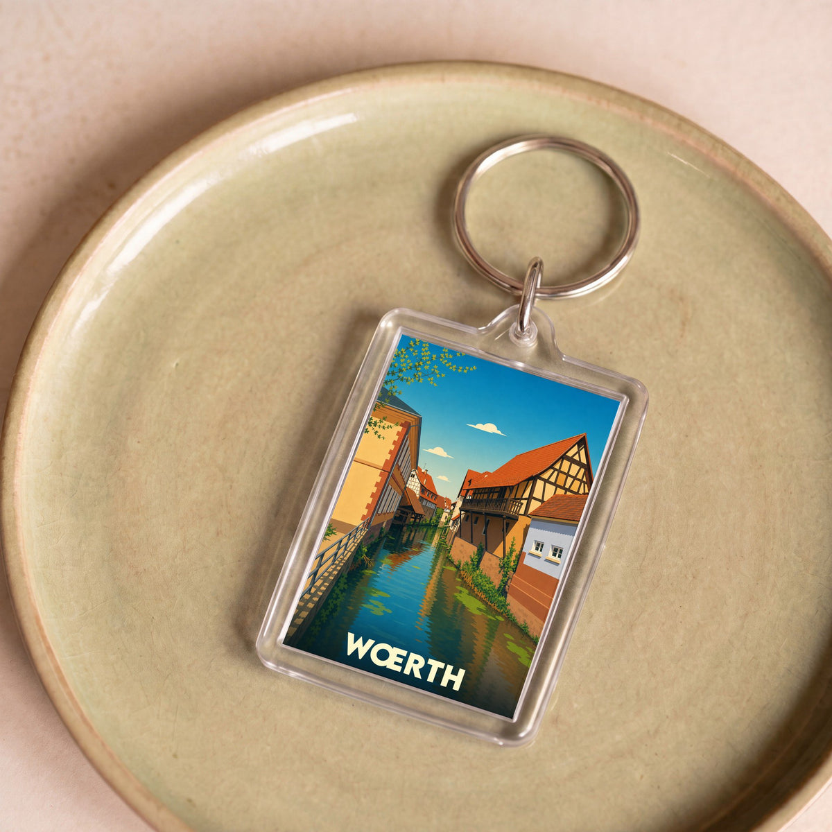 Porte-clés souvenir de la ville de Wœrth avec une illustration stylisée d'un canal bordé de maisons à colombages.