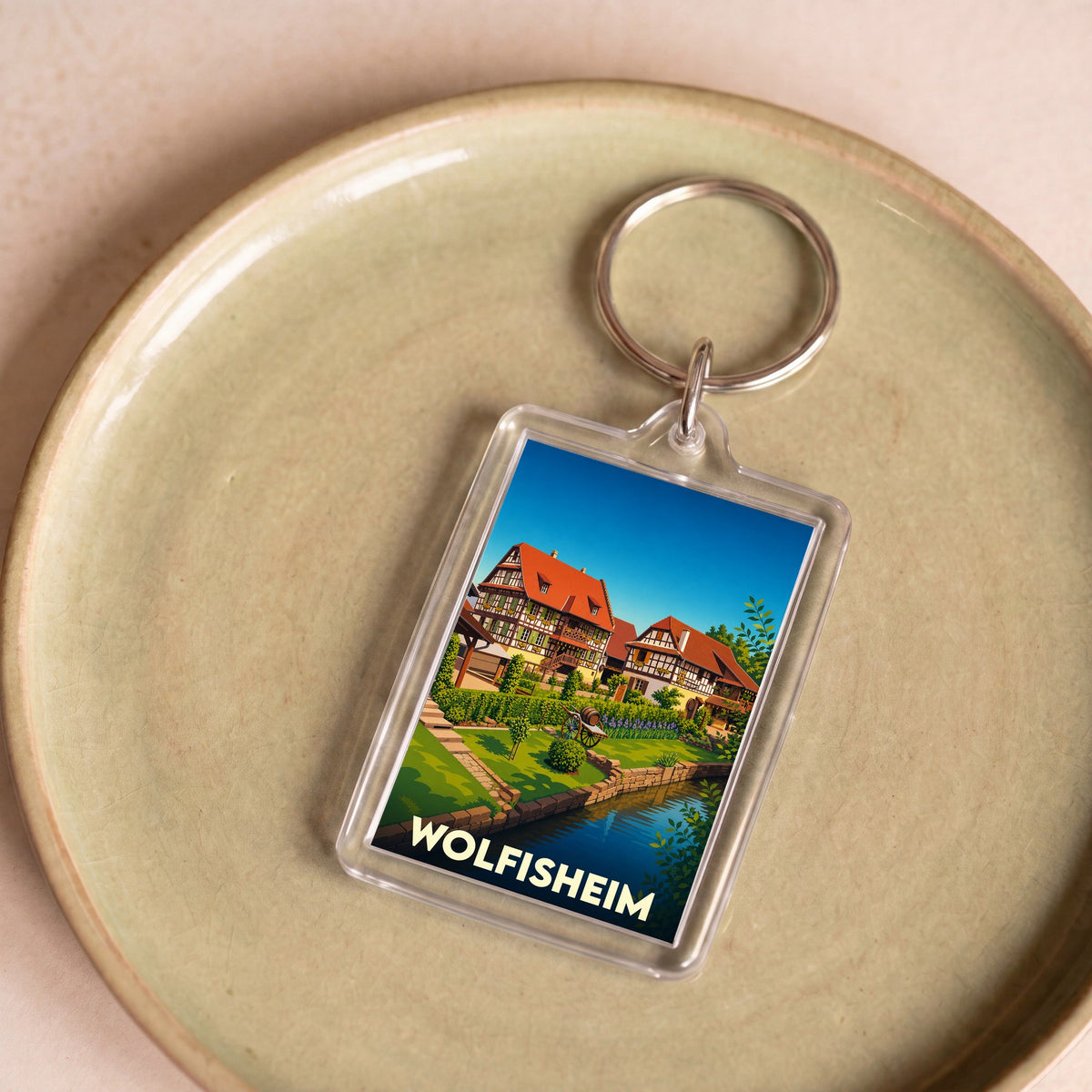Porte-clés souvenir de la ville de Wolfisheim avec une illustration stylisée de maisons à colombages.