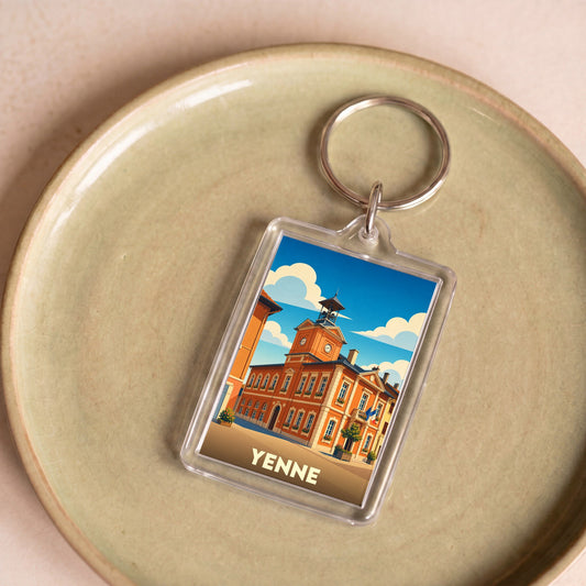 Porte-clés souvenir de la ville de Yenne avec une illustration stylisée de son architecture.