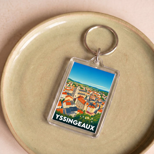 Porte-clés souvenir de la ville d'Yssingeaux avec une illustration stylisée d'un paysage urbain.