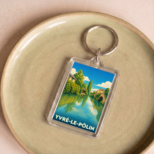 Porte-clés souvenir de la ville de Yvré-le-Pôlin avec une illustration stylisée d'un paysage de rivière.