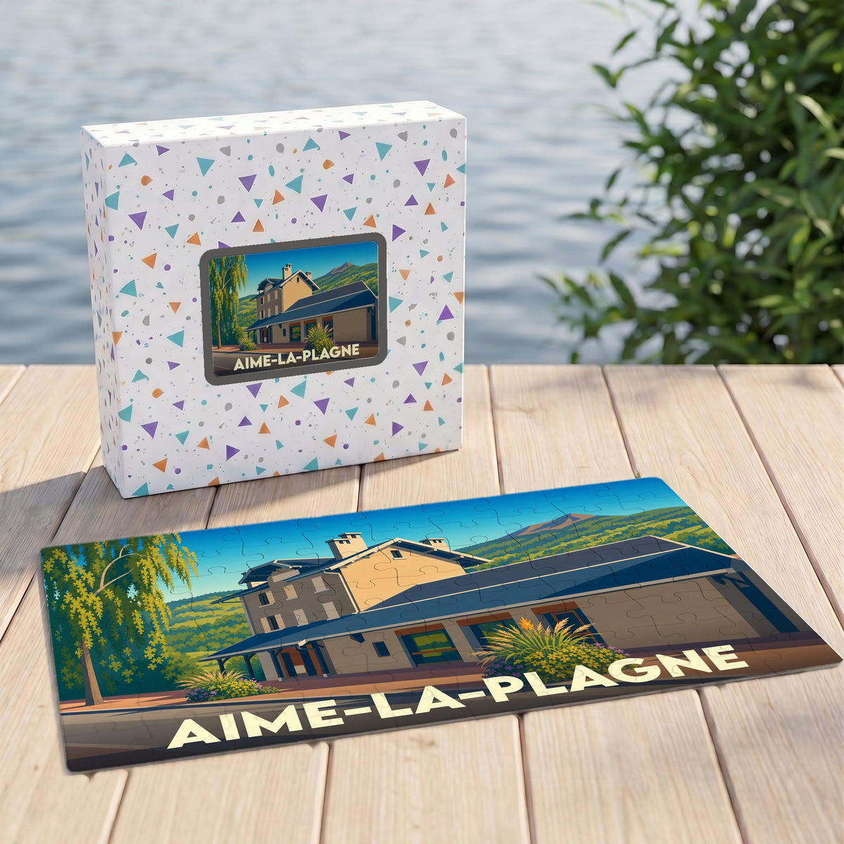 Puzzle souvenir de la ville d'Aime-la-Plagne avec son coffret illustré d'un paysage stylisé.