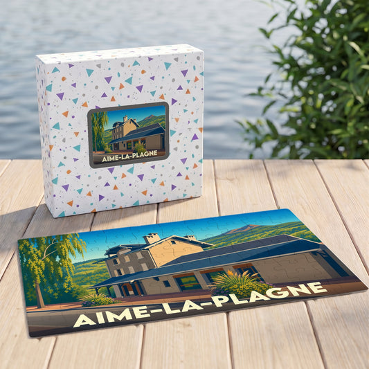 Puzzle souvenir de la ville d'Aime-la-Plagne avec son coffret illustré d'un paysage stylisé.