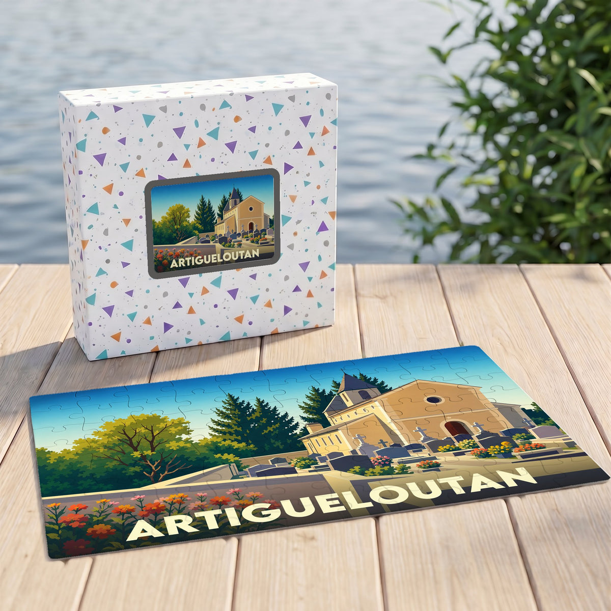 Puzzle souvenir de la ville d'Artigueloutan illustrant une église et son cimetière dans un style graphique épuré.