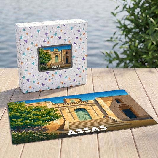 Puzzle souvenir de la ville d'Assas illustrant une façade de bâtiment historique sous un ciel bleu.