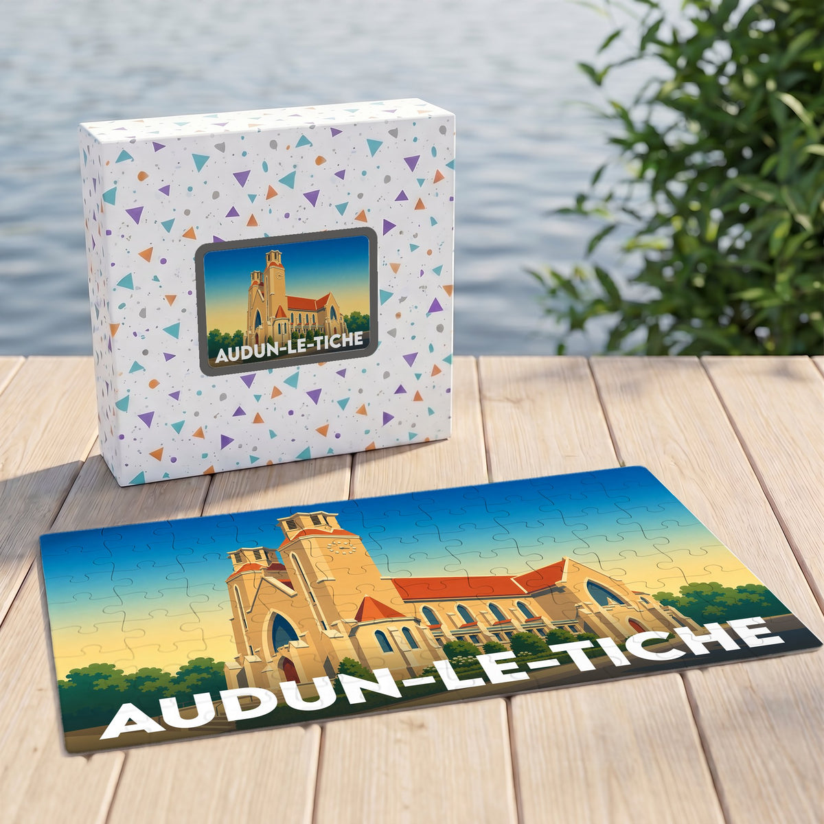 Puzzle souvenir de la ville d'Audun-le-Tiche avec une illustration stylisée de son église et de son nom en lettres capitales.