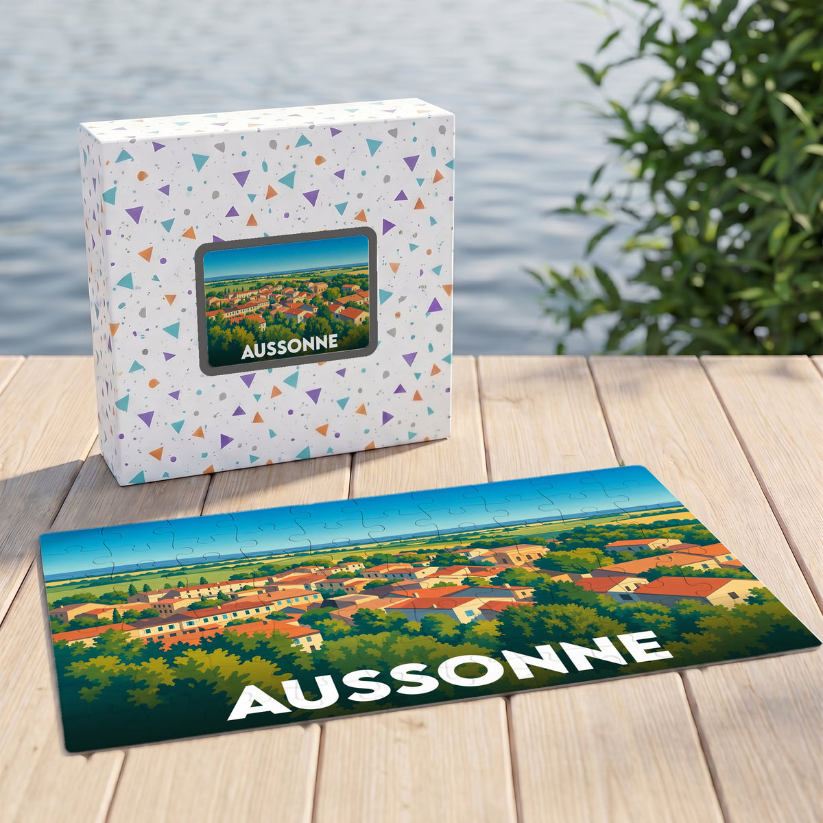Puzzle souvenir de la ville d'Aussonne présentant une vue panoramique illustrée sur une terrasse en bois.