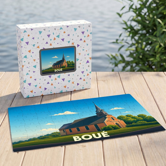 Puzzle souvenir de la ville de Boué avec une illustration stylisée d'une église sous un ciel bleu.
