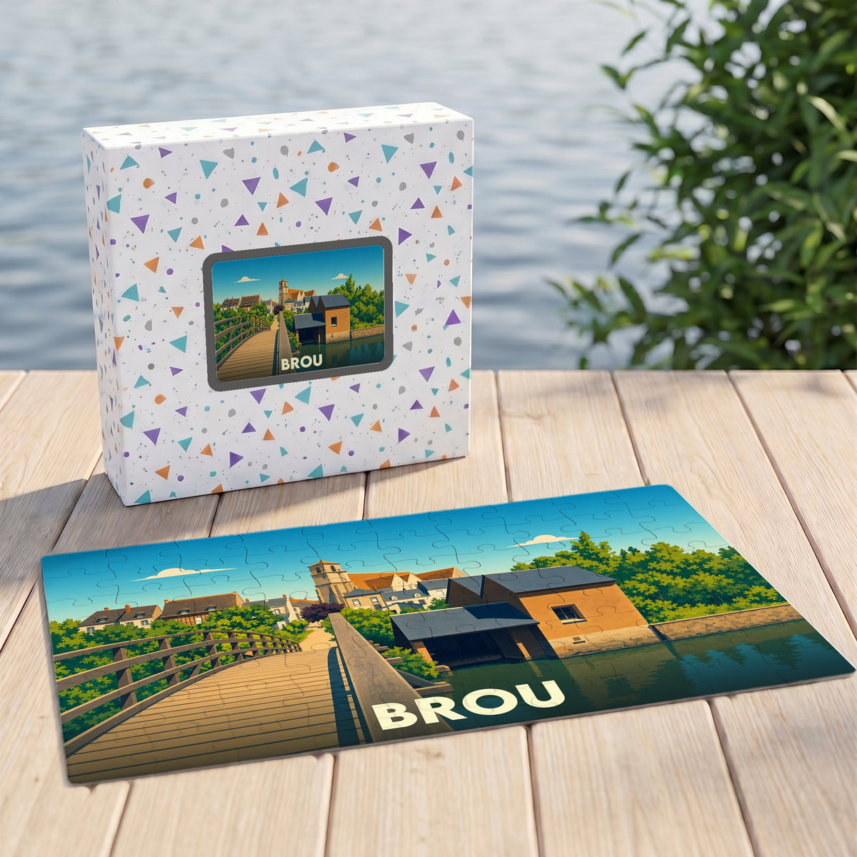 Puzzle souvenir de la ville de Brou avec une illustration stylisée représentant un pont et des maisons au bord de l'eau.