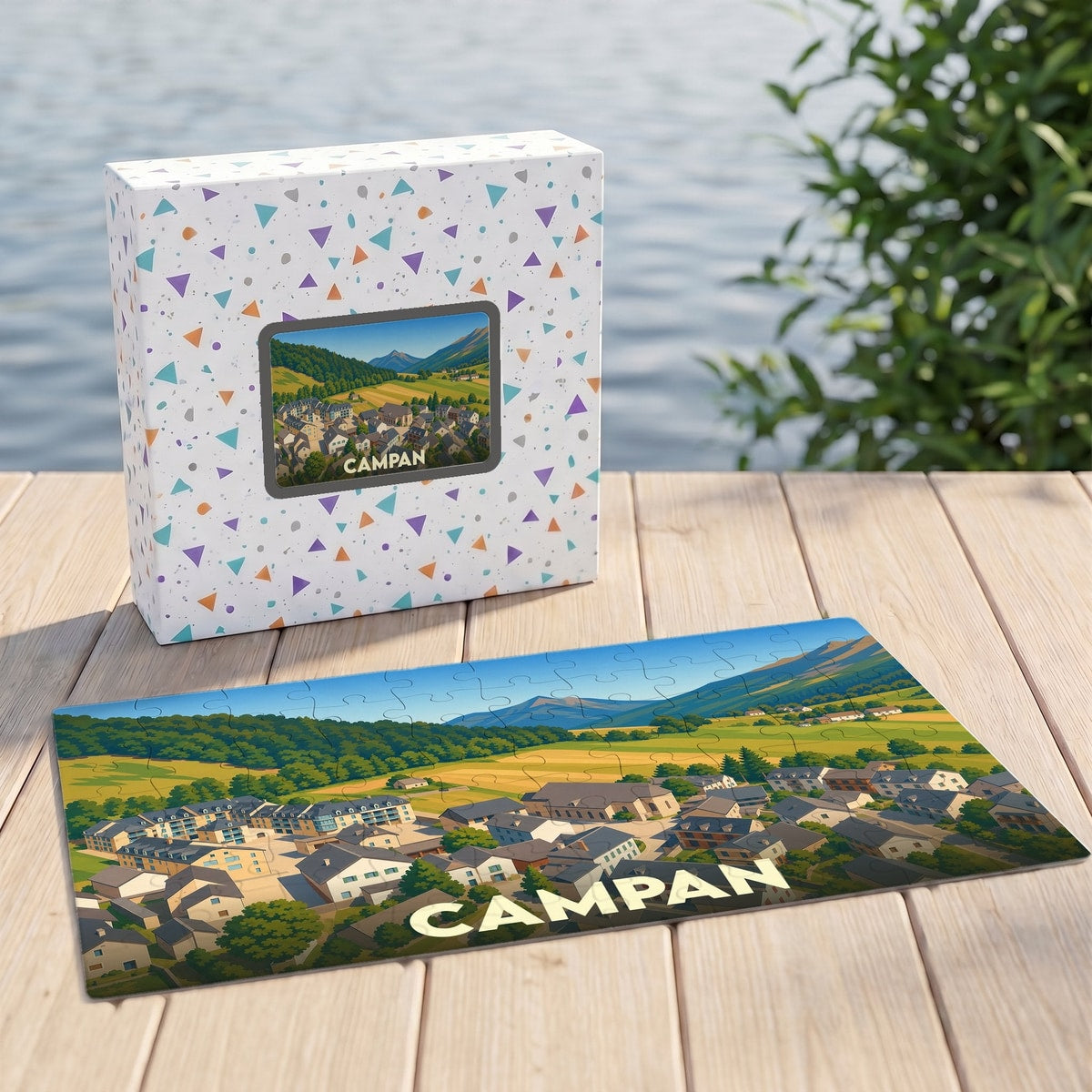 Puzzle souvenir de la ville de Campan avec une illustration stylisée d'un paysage montagneux et de ses habitations.