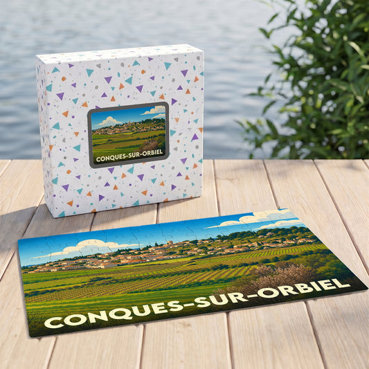 Puzzle souvenir de la ville de Conques-sur-Orbiel présentant une illustration stylisée de son paysage de vignobles.