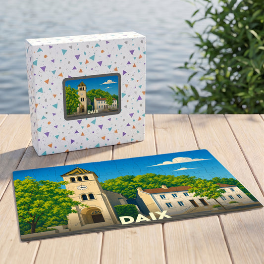 Puzzle souvenir de la ville de Daix illustrant une église et des bâtiments sous un ciel bleu.