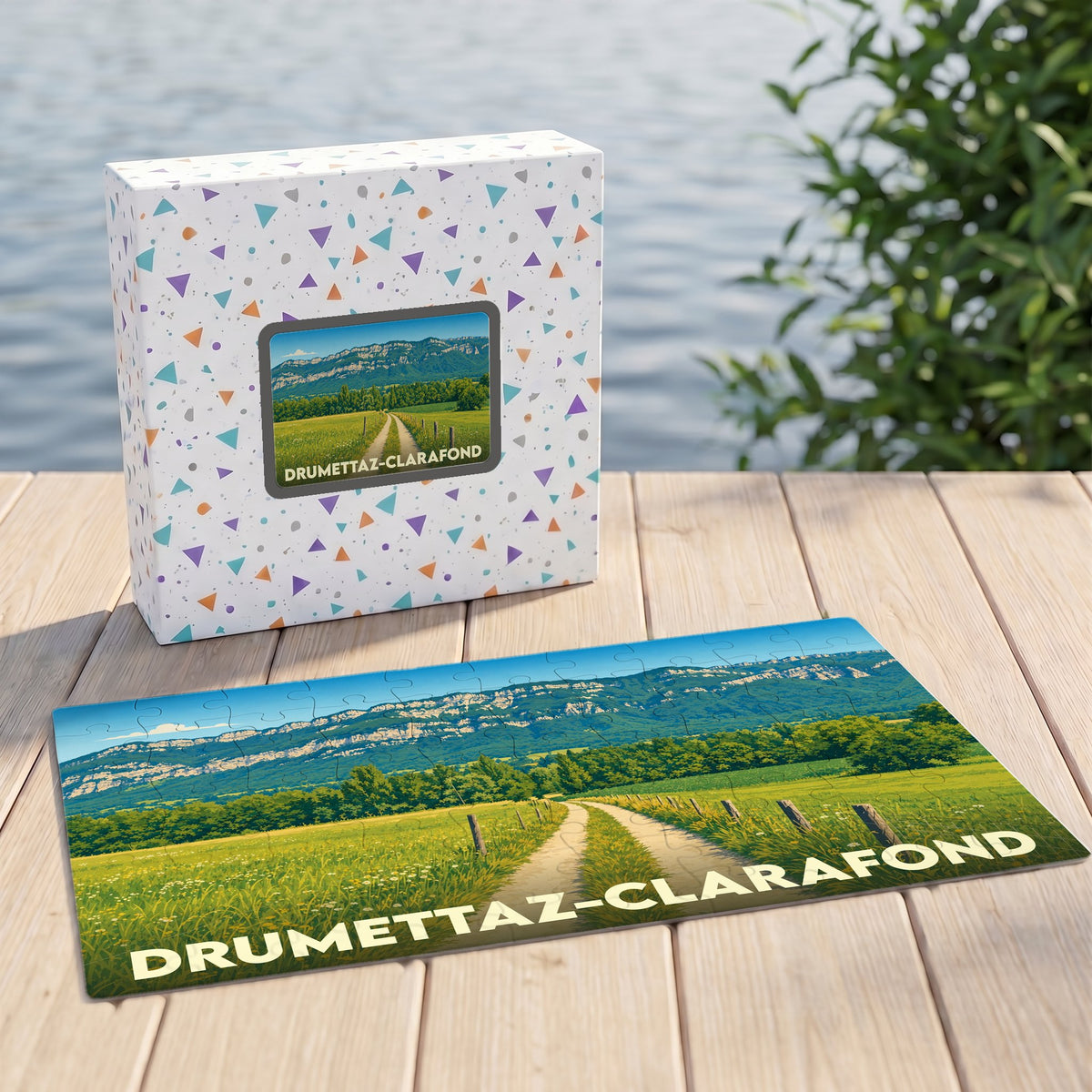 Puzzle souvenir de la ville de Drumettaz-Clarafond illustrant un paysage de campagne avec montagnes en arrière-plan.