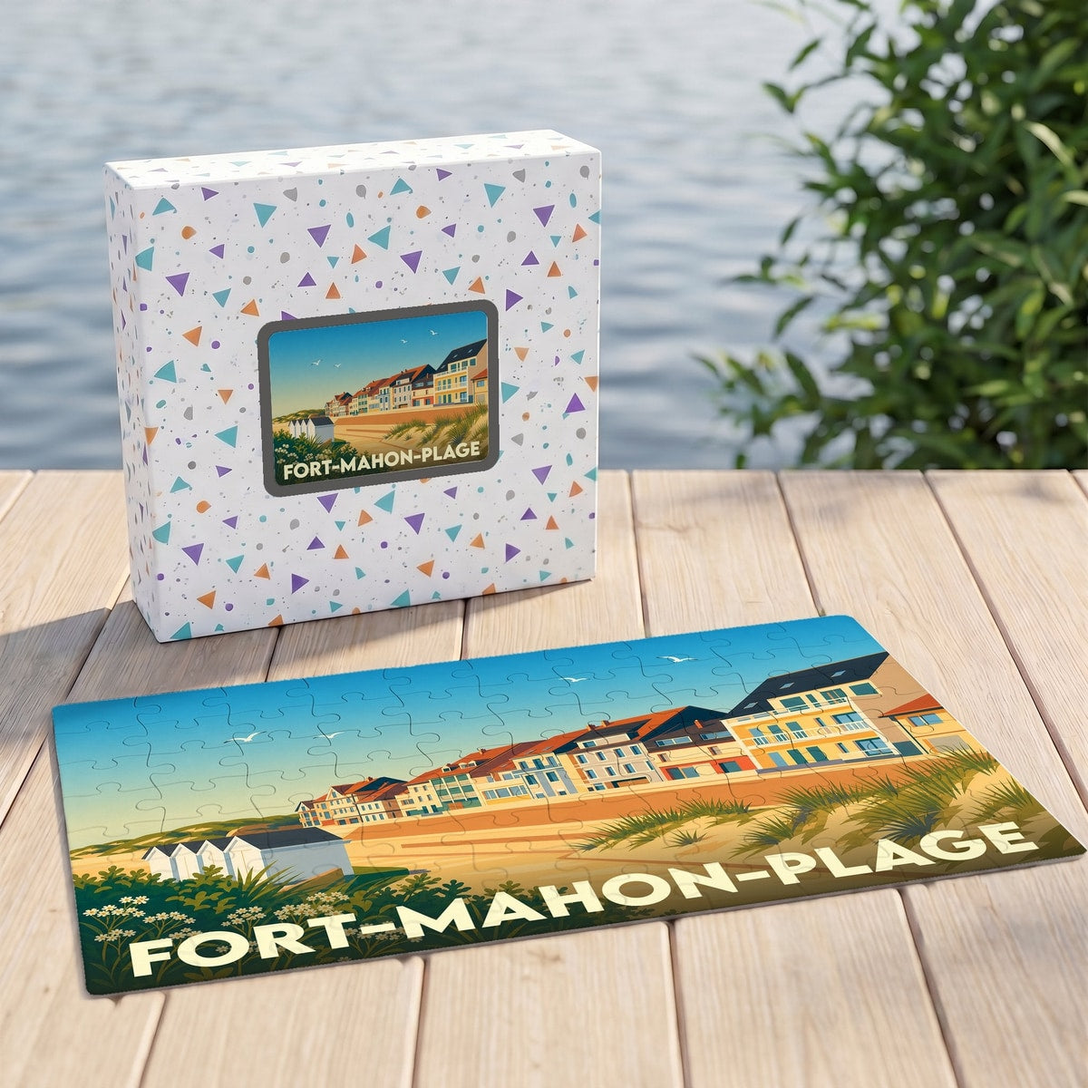 Puzzle souvenir de Fort-Mahon-Plage illustrant son front de mer sur un plateau en bois devant sa boîte assortie.