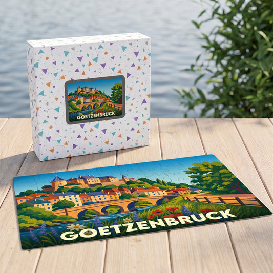 Puzzle souvenir de la ville de Goetzenbruck illustrant un paysage coloré avec pont et château.