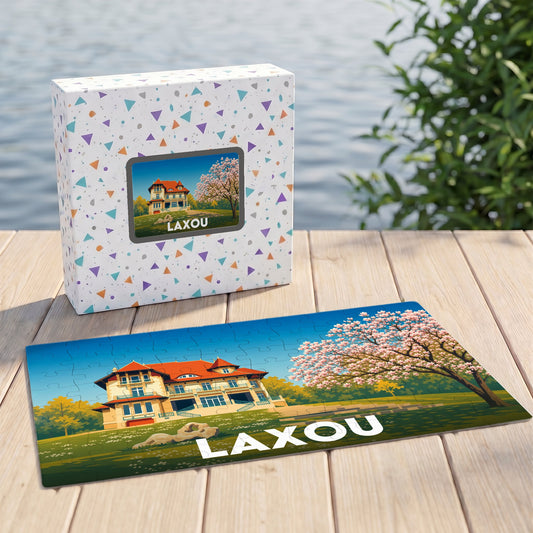 Puzzle souvenir de la ville de Laxou avec une illustration stylisée de villa et de cerisiers.