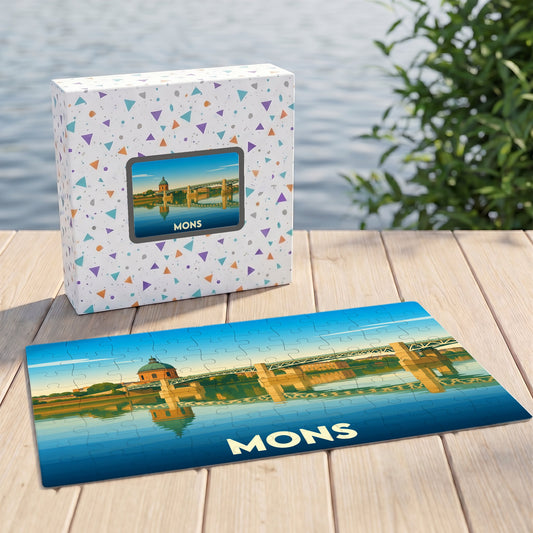 Puzzle souvenir de la ville de Mons présentant une illustration stylisée d'un pont et d'un dôme se reflétant sur l'eau.