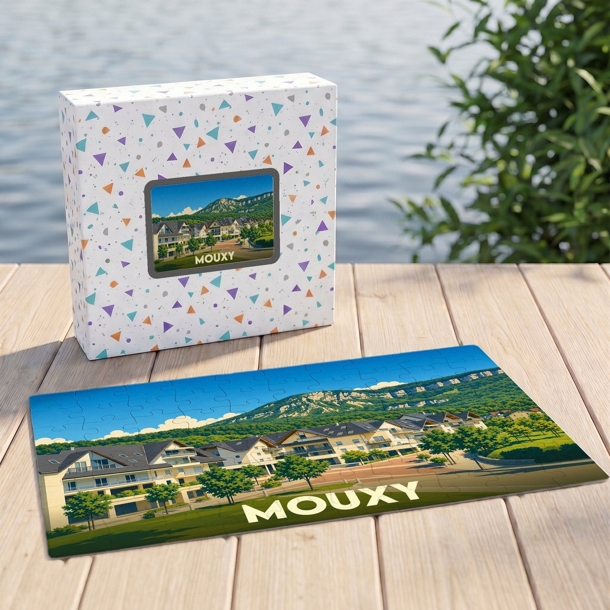 Puzzle souvenir de la ville de Mouxy avec une illustration stylisée de ses habitations et montagnes.
