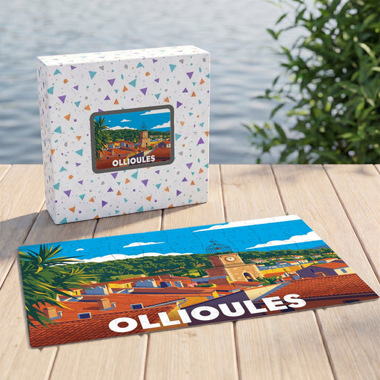 Puzzle souvenir de la ville d'Ollioules représentant une vue panoramique illustrée de ses toits et de son clocher.