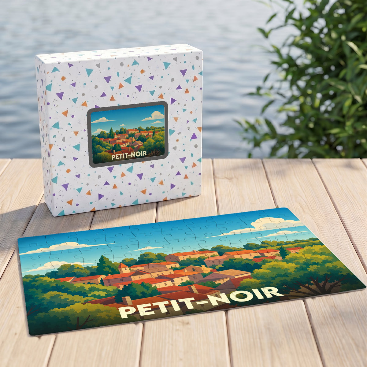 Puzzle souvenir de la ville de Petit-Noir avec une illustration stylisée d'un village paysager.