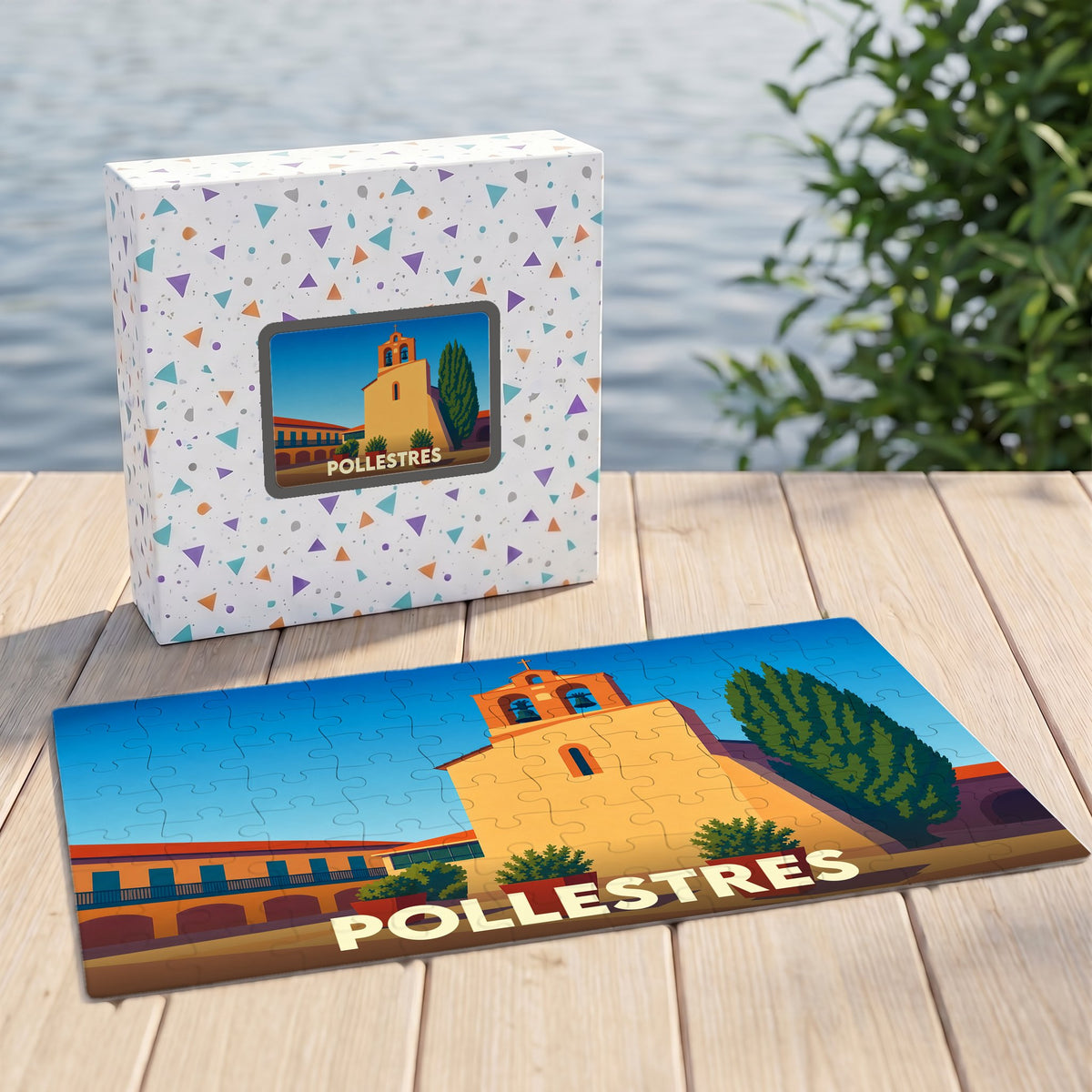 Puzzle souvenir de la ville de Pollestres avec une illustration stylisée et sa boîte assortie sur un ponton en bois.