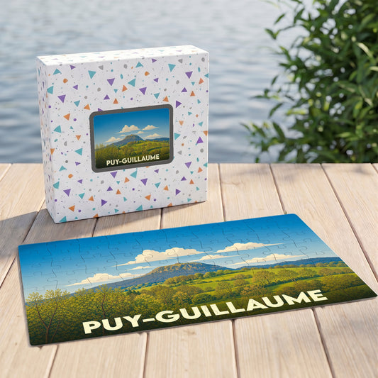 Puzzle souvenir de la ville de Puy-Guillaume illustré par un paysage vallonné sous un ciel bleu.