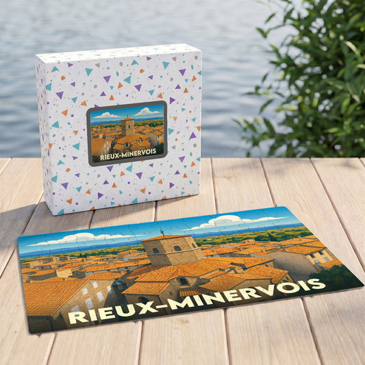 Puzzle souvenir de la ville de Rieux-Minervois avec son coffret assorti présentant une illustration stylisée des toits occitans.