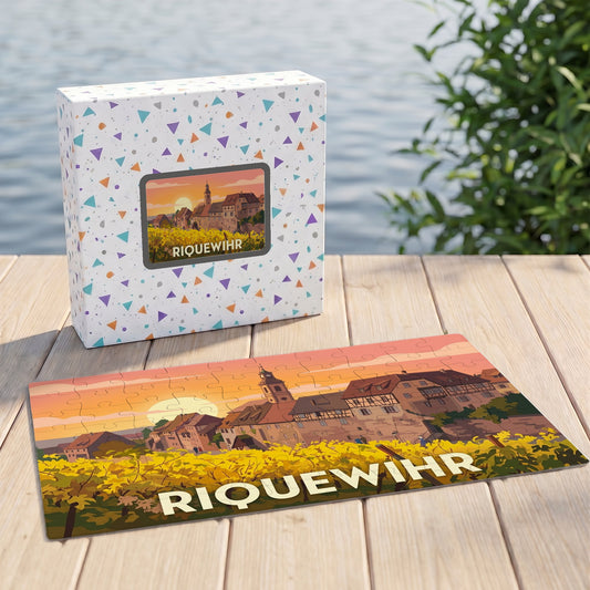 Puzzle souvenir de la ville de Riquewihr avec une illustration stylisée d'un paysage alsacien au soleil couchant.