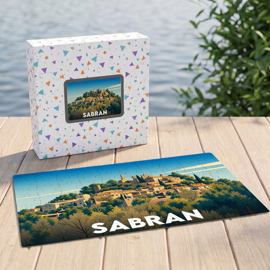 Puzzle souvenir de la ville de Sabran avec une illustration stylisée d'un village perché.
