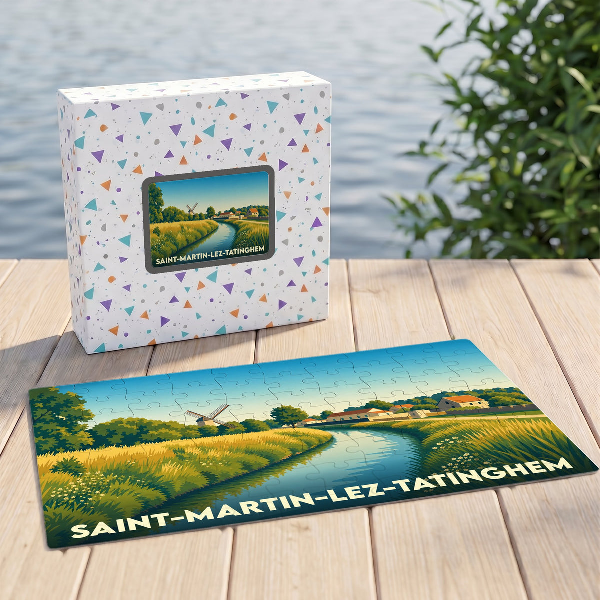 Puzzle souvenir de la ville de Saint-Martin-lez-Tatinghem illustrant un paysage de campagne avec un moulin et un cours d'eau.