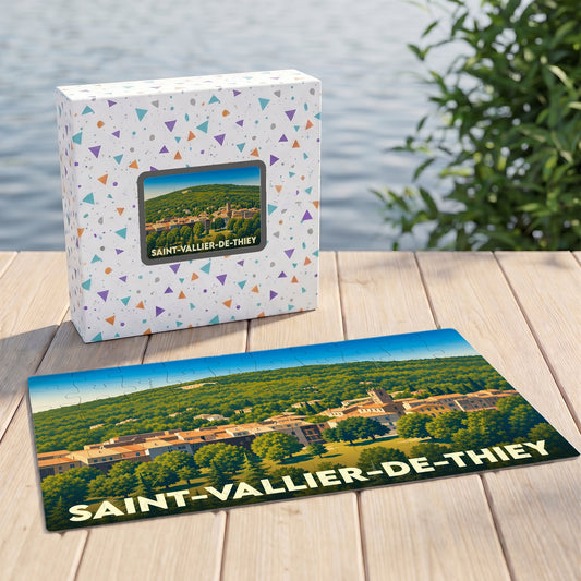 Puzzle souvenir de la ville de Saint-Vallier-de-Thiey avec son coffret assorti, présentant une illustration stylisée d'un village provençal.