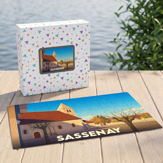 Puzzle souvenir de la ville de Sassenay avec une illustration stylisée d'une église sous un ciel bleu.