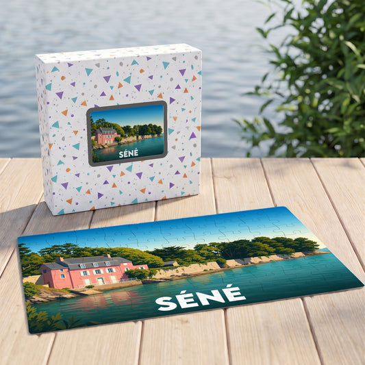 Puzzle souvenir de la ville de Séné présentant une illustration stylisée d'une maison rose en bord de mer.