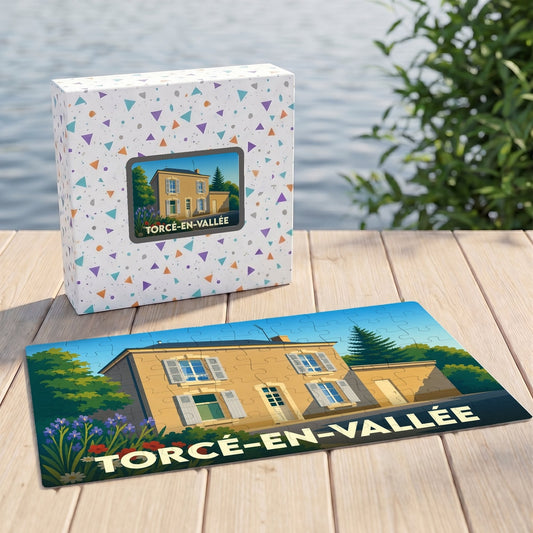 Puzzle souvenir de la ville de Torcé-en-Vallée avec une illustration stylisée d'une maison régionale.