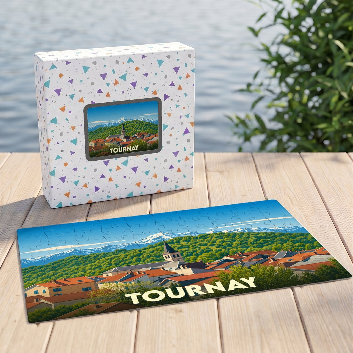Puzzle souvenir de la ville de Tournay avec une illustration stylisée des montagnes et du village.