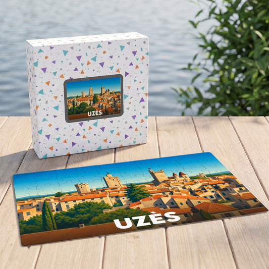 Puzzle souvenir de la ville d'Uzès avec une illustration panoramique stylisée, accompagné de sa boîte de rangement assortie.