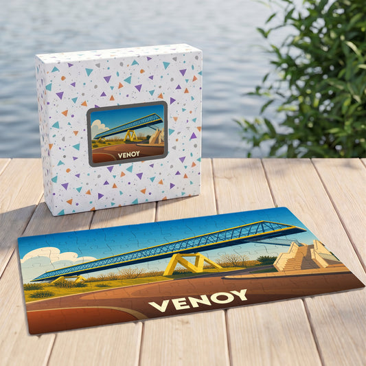 Puzzle souvenir de la ville de Venoy illustrant une passerelle moderne sur un fond paysager coloré.