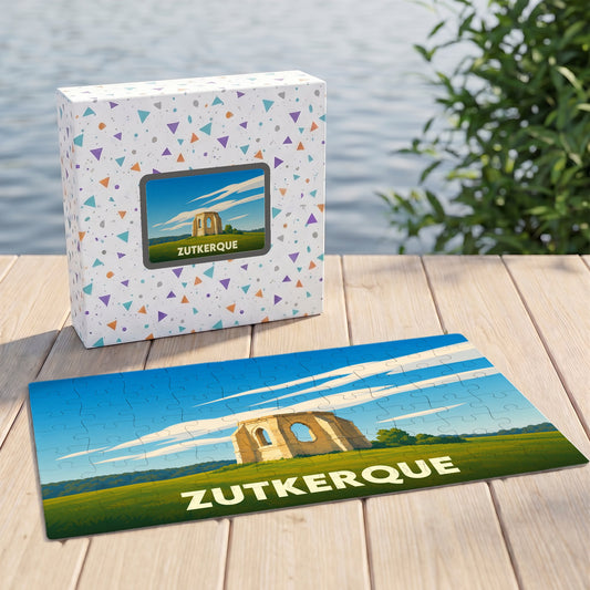 Puzzle souvenir de la ville de Zutkerque illustrant un monument historique sous un ciel bleu.