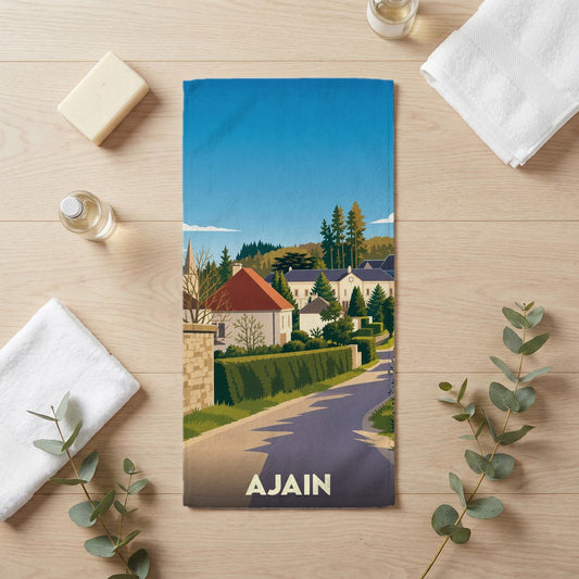 Serviette de bain souvenir de la ville d'Ajain avec une illustration stylisée d'un paysage urbain.