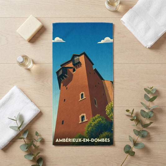 Serviette de bain souvenir de la ville d'Ambérieux-en-Dombes avec une illustration stylisée d'une tour historique.