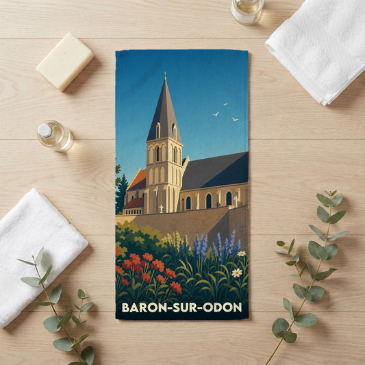 Serviette de bain souvenir de Baron-sur-Odon avec une illustration stylisée de son église et de son jardin.