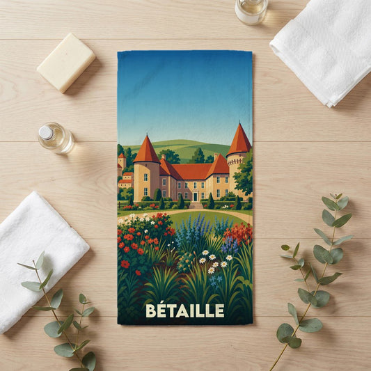 Serviette de bain souvenir de la ville de Bétaille avec une illustration stylisée d'un château et de jardins.
