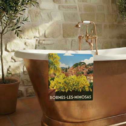 Serviette de bain souvenir de Bormes-les-Mimosas avec une illustration stylisée du village et de mimosas en fleurs.