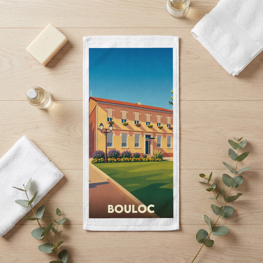 Serviette de bain souvenir de la ville de Bouloc avec une illustration stylisée d'un bâtiment fleuri.