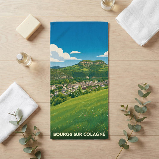 Serviette de bain souvenir de la ville de Bourgs sur Colagne avec une illustration de paysage champêtre.