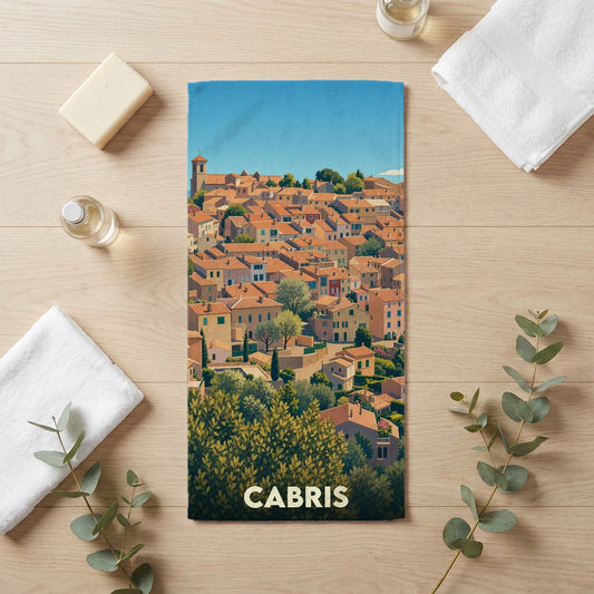 Serviette de bain souvenir de la ville de Cabris avec une illustration stylisée d'un village provençal.